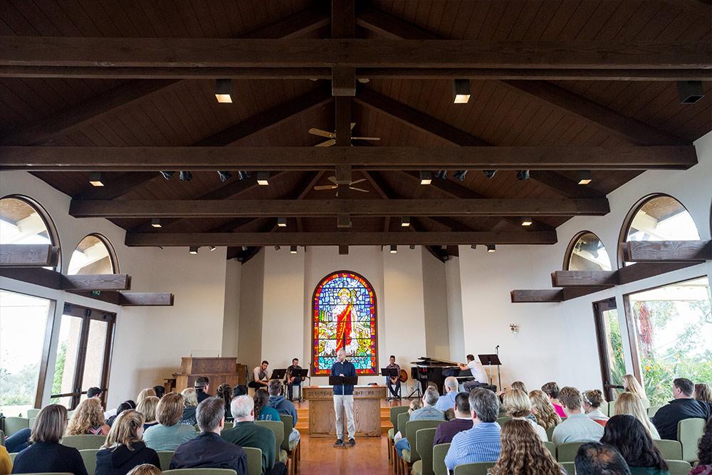 A speaker welcomes the audience at Good Shepherd Chapel.